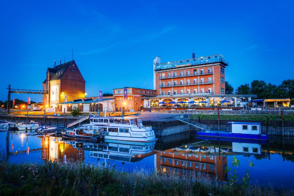 德米茨多米茨哈芬酒店的码头上夜间有船只的建筑