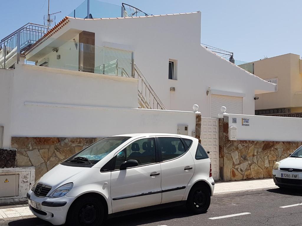 美洲海滩Casa Julia的停在房子前面的停车场的白色汽车