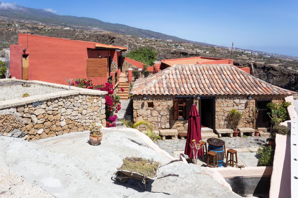 FasniaLa casa de Aya的一座村庄,一座建筑和一座带椅子和遮阳伞的房子