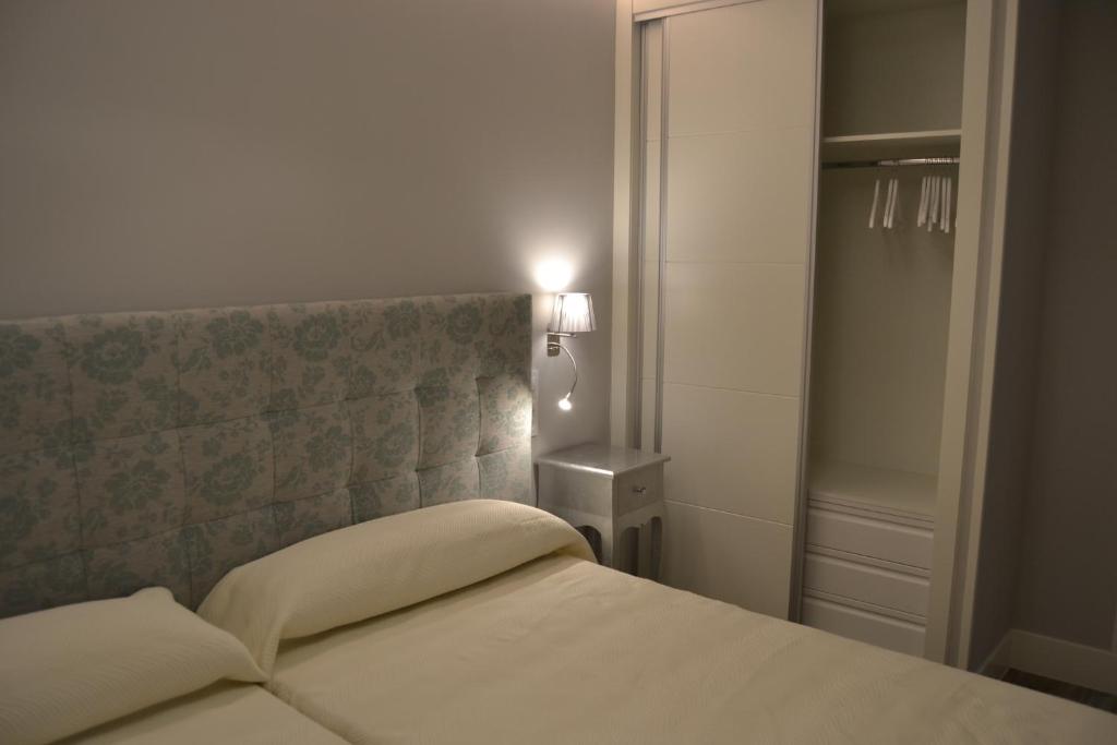 La PueblanuevaHotel Español的一间卧室配有一张带床头板和灯的床