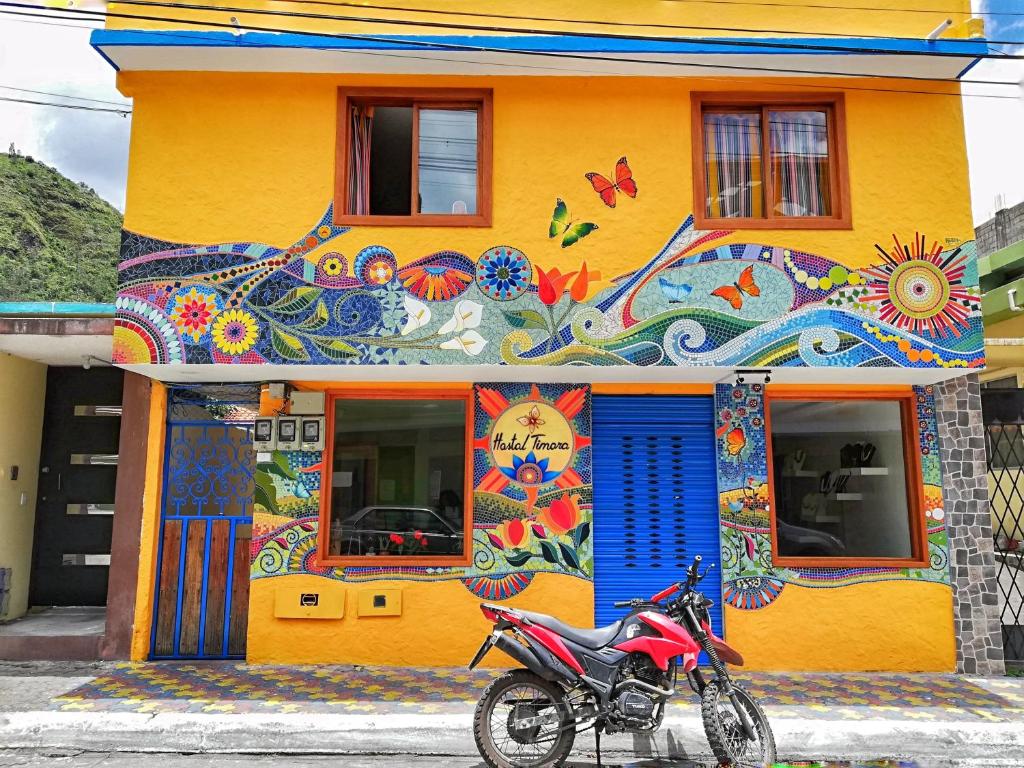 巴尼奥斯Hostal Timara的停在多彩建筑前面的摩托车
