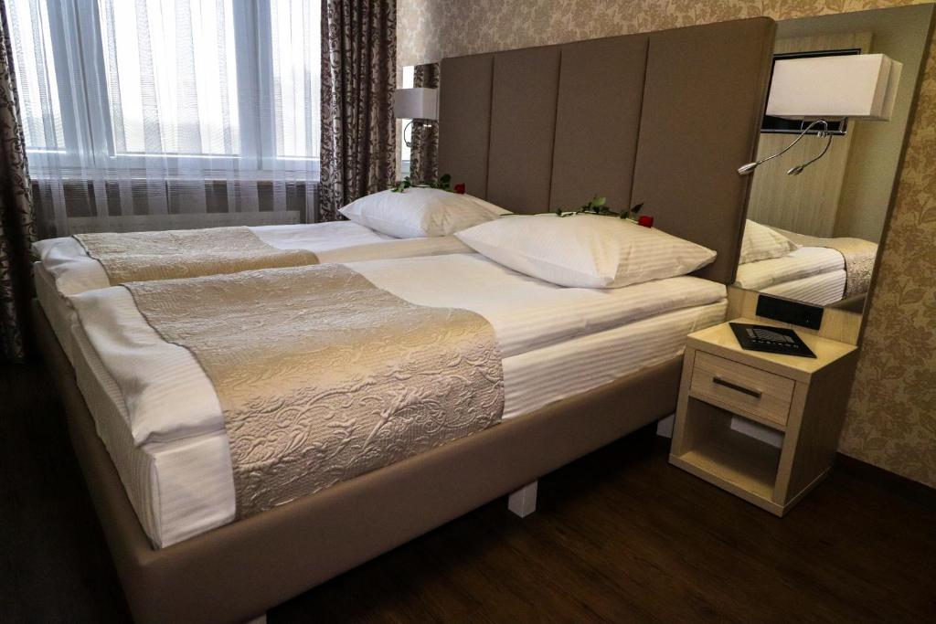 卢布林Kompleks restauracyjno-noclegowy Rubikon的一张位于酒店客房的大床,配有镜子