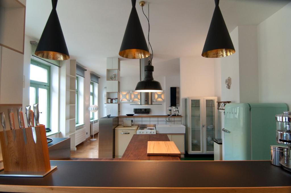 德累斯顿Sachsenperle的厨房配有木桌和黑色吊灯