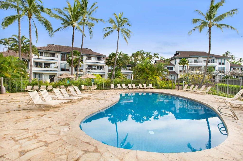 科洛阿波普凯雅诗顿公寓式酒店的一个带躺椅的游泳池,棕榈树