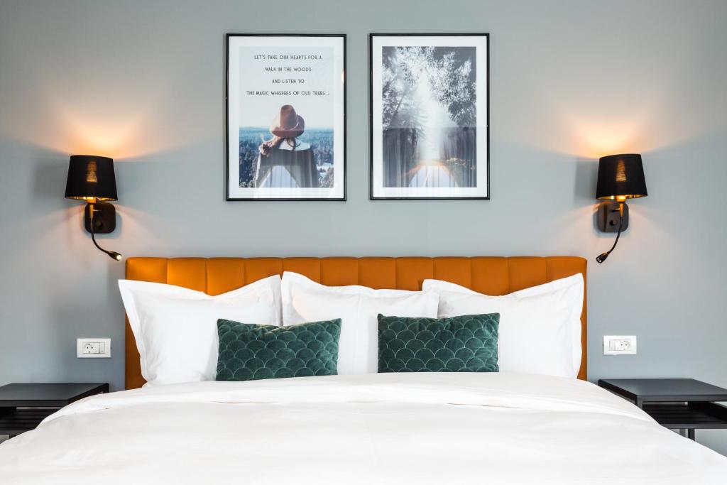 布拉索夫UpperHouse Suites & More的卧室配有一张墙上有两张照片的床。
