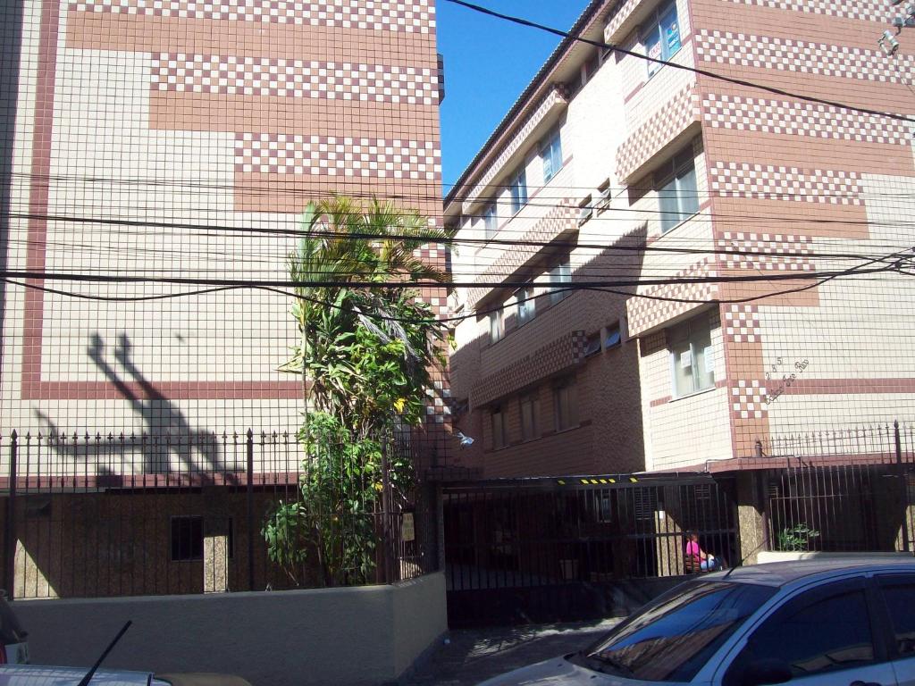卡波布里奥APARTAMENTO A 200 M DA PRAIA DO FORTE -PRÉDIO TRÊS RIOS的一条有两座高楼和一辆汽车的街道