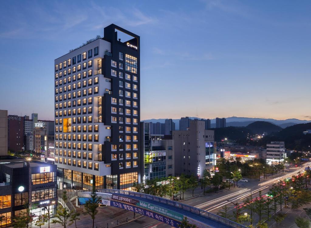 江陵市Gangneung City Hotel的夜晚在城市的高楼