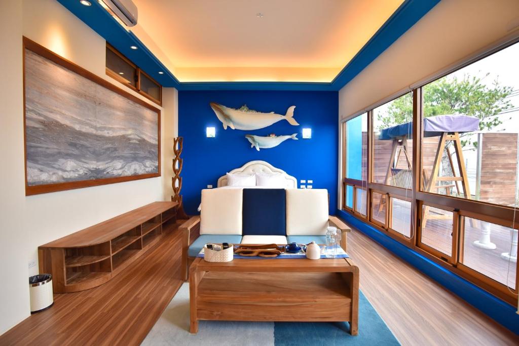 Shigang彩虹山舍 的一间拥有蓝色墙壁、一张床和一张桌子的房间