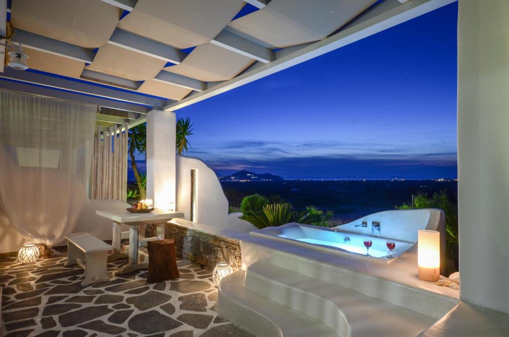 Glinado NaxosNaxos Villa Bella Vista的晚间在阳台上设有浴缸的别墅