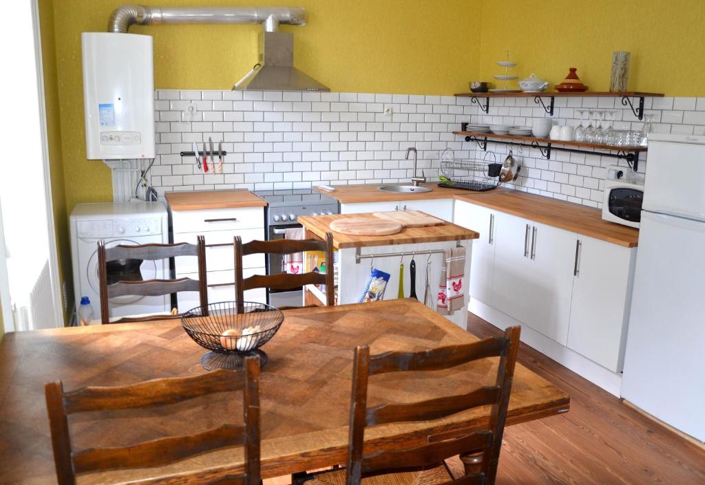 佩里格Joli appartement vue sur l'Eglise的厨房配有木桌和椅子