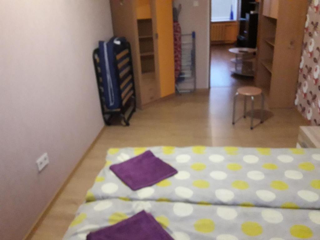 Aizkraukle2 istabu dzīvoklis的紫色和黄色床单间的一张床位
