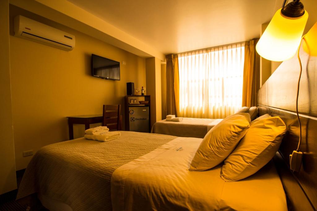 帕卡斯马约El Puerto Hotel的配有两张枕头的床的酒店客房