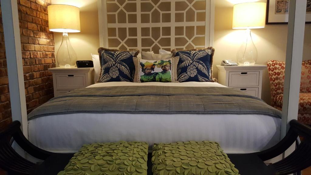 巴利纳波丽娜棕榈精品汽车旅馆的一间卧室配有一张大床和两盏灯