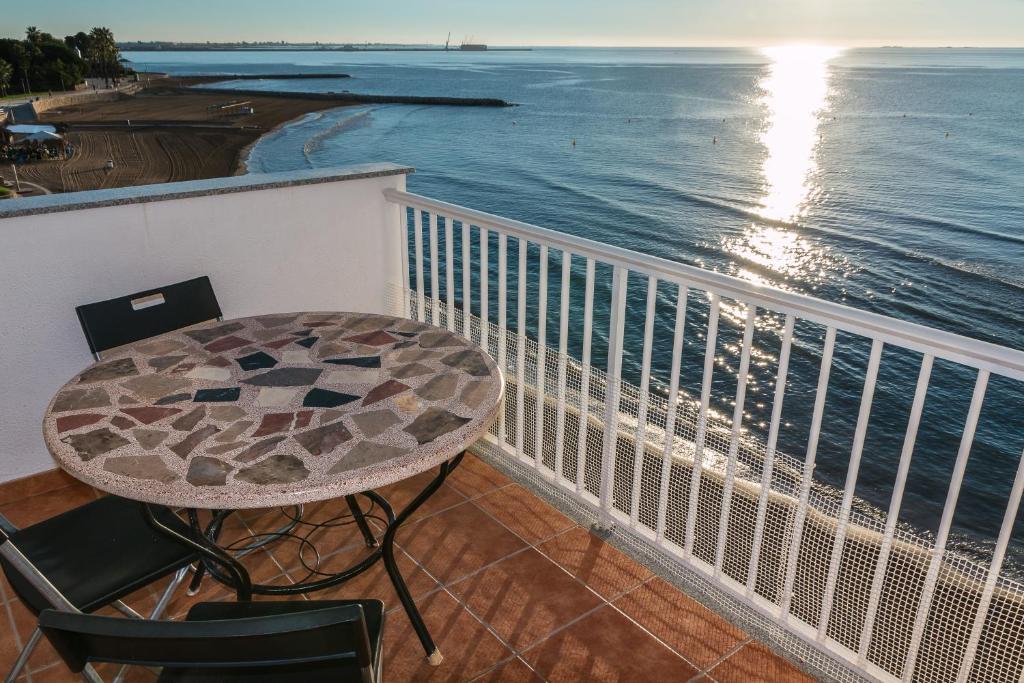 圣卡洛斯拉腊皮塔Apartamento en primera línea de mar的俯瞰大海的阳台配有桌椅