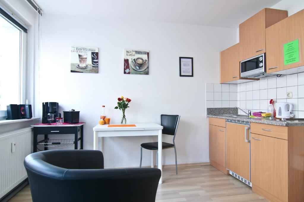 科隆拉赫中央顶级公寓的小厨房配有2把椅子和桌子