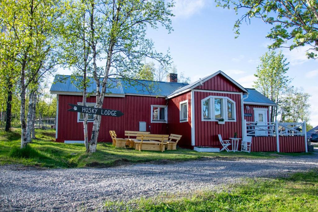 基律纳Husky Lodge Hostel的一间红色的房子,前面设有一张野餐桌