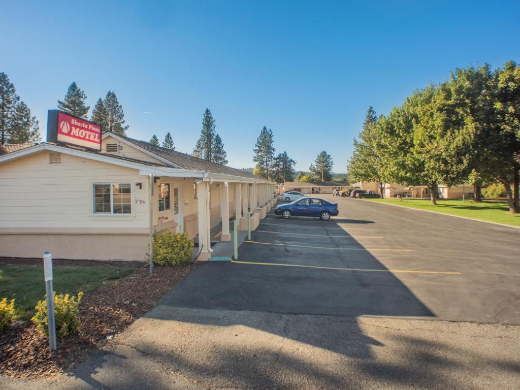 BurneyShasta Pines Motel & Suites的停车场停在大楼前