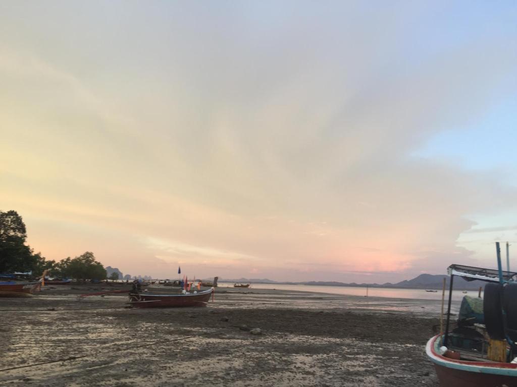 董里Koh Mook Rem Ley的日落时分在海滩上坐的一群船