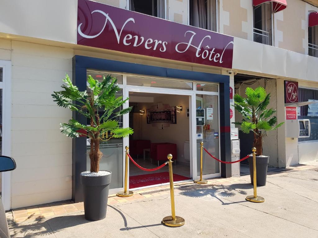 讷韦尔Nevers Hotel的前面有两棵棕榈树的商店