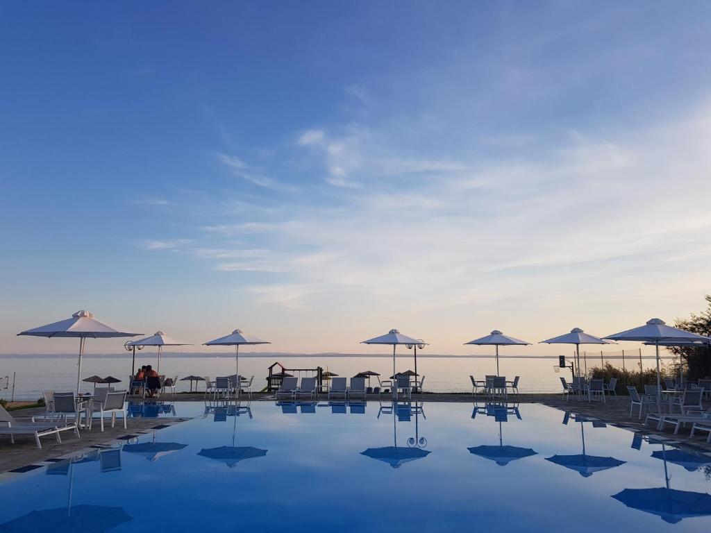 基拉奇尼阿尔客诺俄斯海滩公寓式酒店的一个带桌子和遮阳伞的游泳池