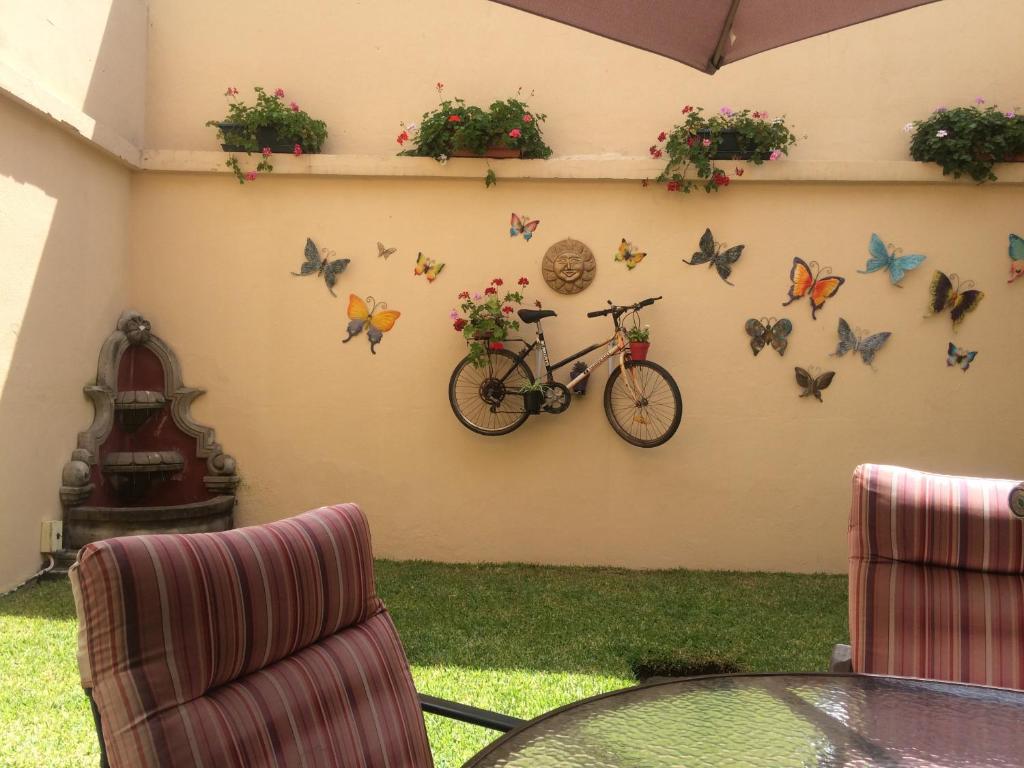 危地马拉Hostal Los Lagos Inn的挂在墙上的自行车,上面挂着蝴蝶