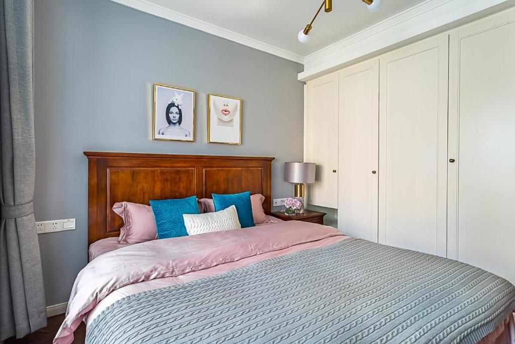 长沙长沙市岳麓区·梅溪湖·路客精品公寓·00165310的一间卧室配有一张大床,配有粉色和蓝色的枕头