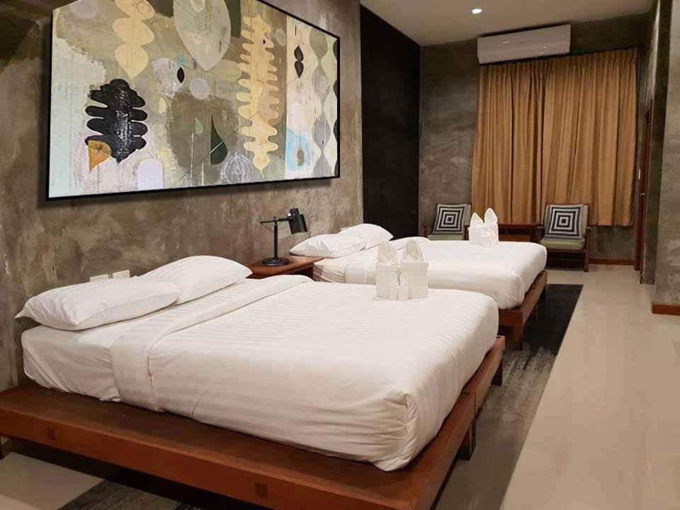 华欣D Huahin Vintage & Loft的酒店客房,配有3张带白色床单的床