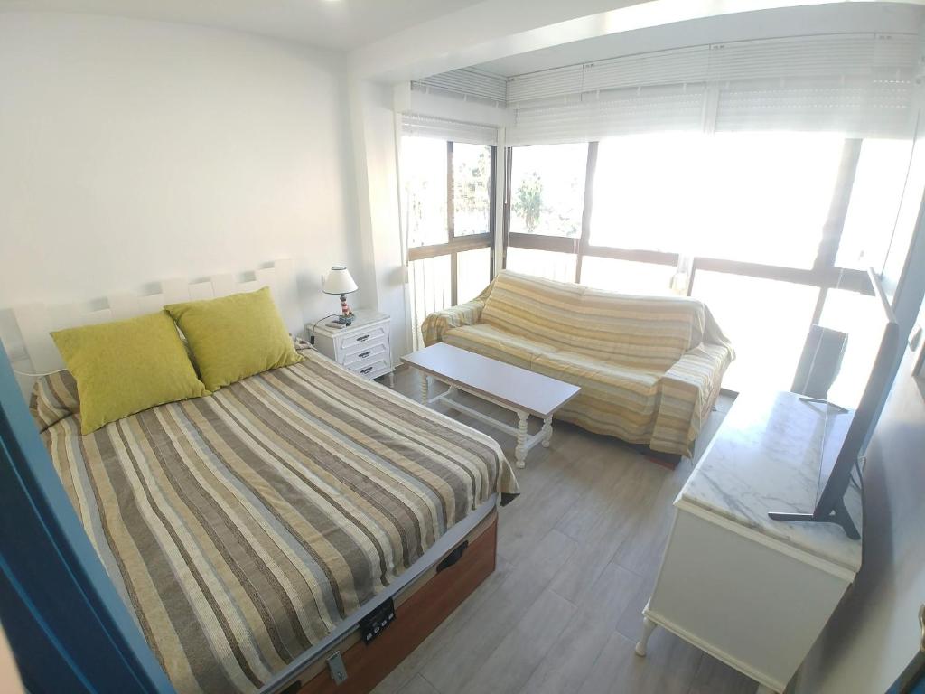 阿尔姆尼卡Apartamento Caléndula的一间带两张床和一张沙发的小卧室