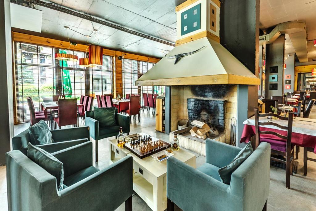 班斯科3 Mountains Hotel的一间设有蓝色椅子和壁炉的餐厅