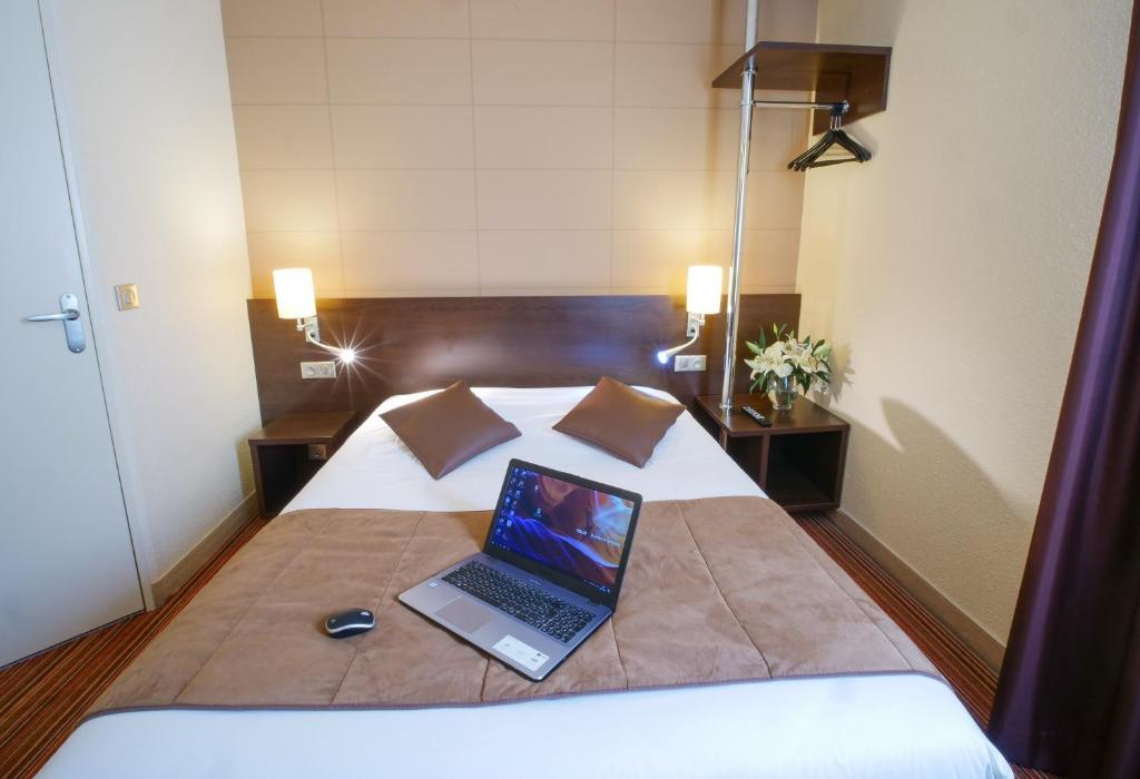 普瓦捷Hotel Inn Design Poitiers Sud的床上的笔记本电脑