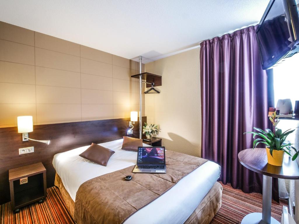 阿朗松阿朗松诺瓦设计酒店的酒店客房,配有一张带笔记本电脑的床