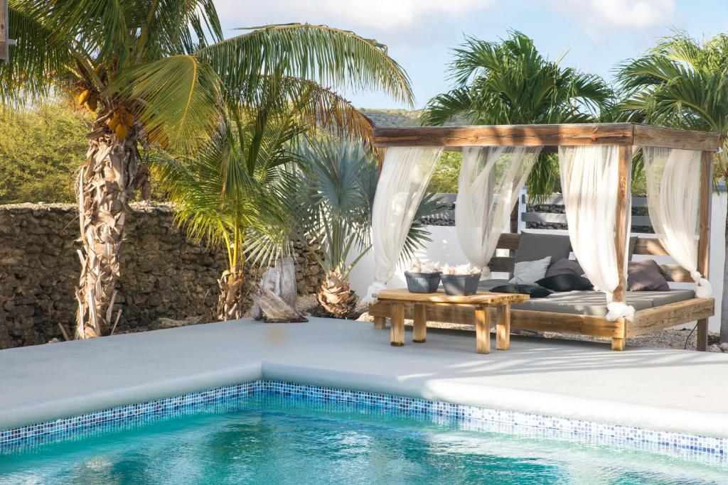 克拉伦代克Hakuna Matata Bonaire - Beach & Diving的游泳池旁设有凉亭和桌子