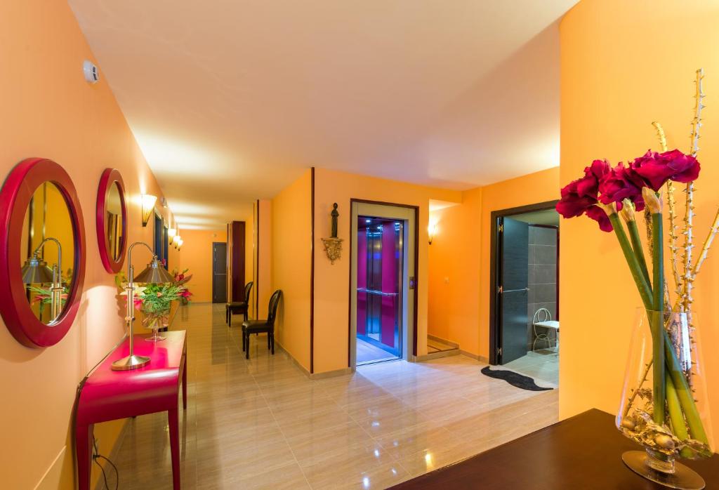 阿尔苏阿Albergue Vía Láctea的走廊上设有橙色墙壁和花瓶,摆放在桌子上