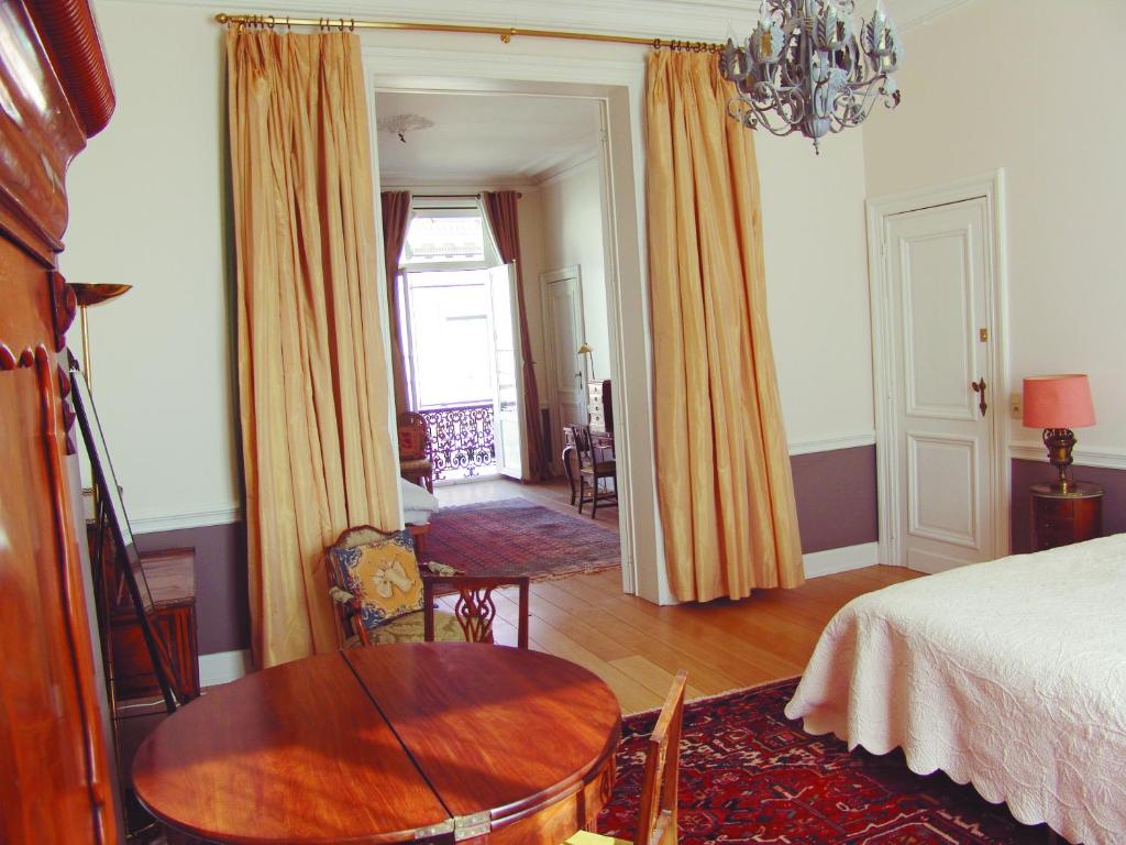 布鲁塞尔Louise Chatelain suites的一间带桌子和床的卧室以及一间客房