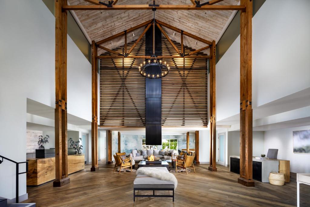 滨海城圣地海滩度假酒店的开放式客厅设有木梁和大型天花板