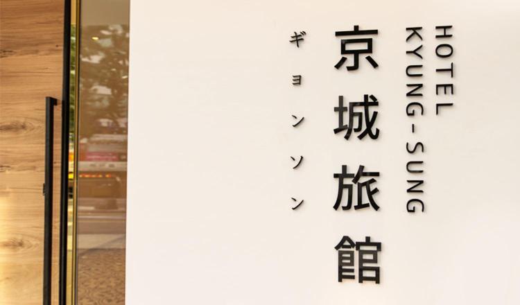 釜山Hotel Kyungsung的玻璃门上带有日本文字的标志
