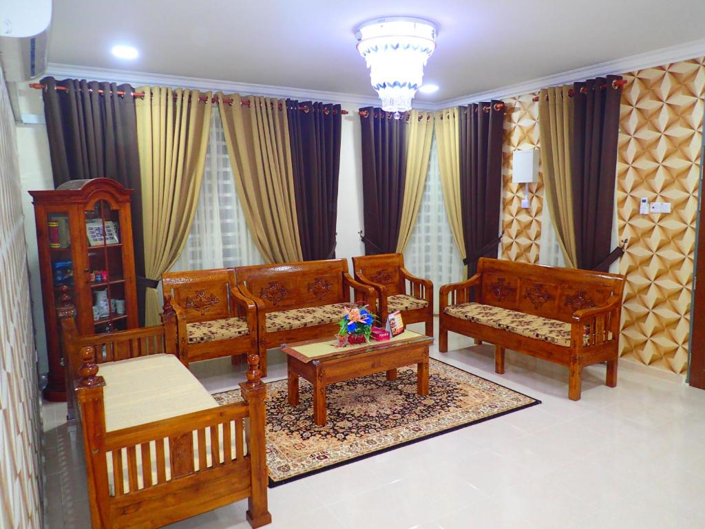 巴佐RizQin Homestay Bachok的客厅配有木制家具和窗帘