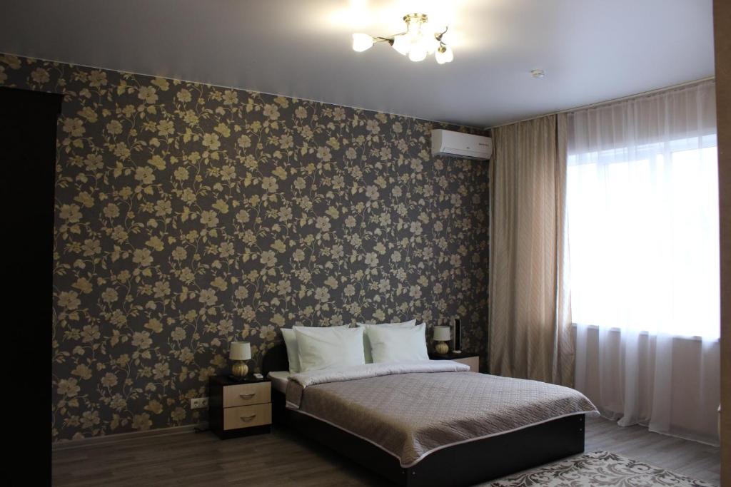 彼尔姆Sofia Hotel的一间卧室配有一张带花卉壁纸的床