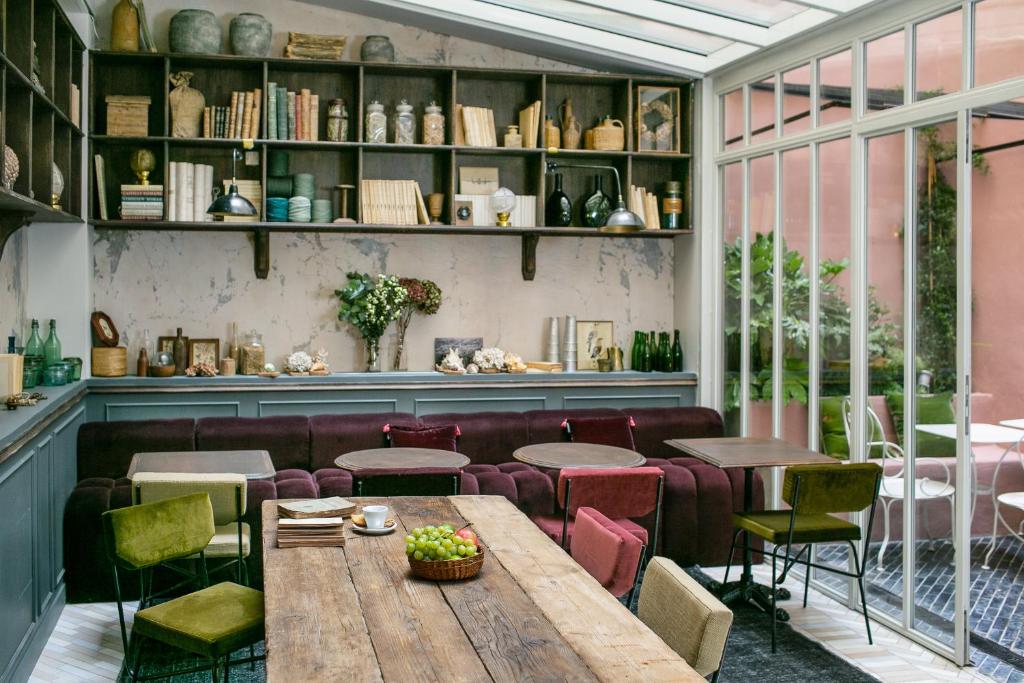 巴黎La Planque Hotel的餐厅配有木桌和椅子