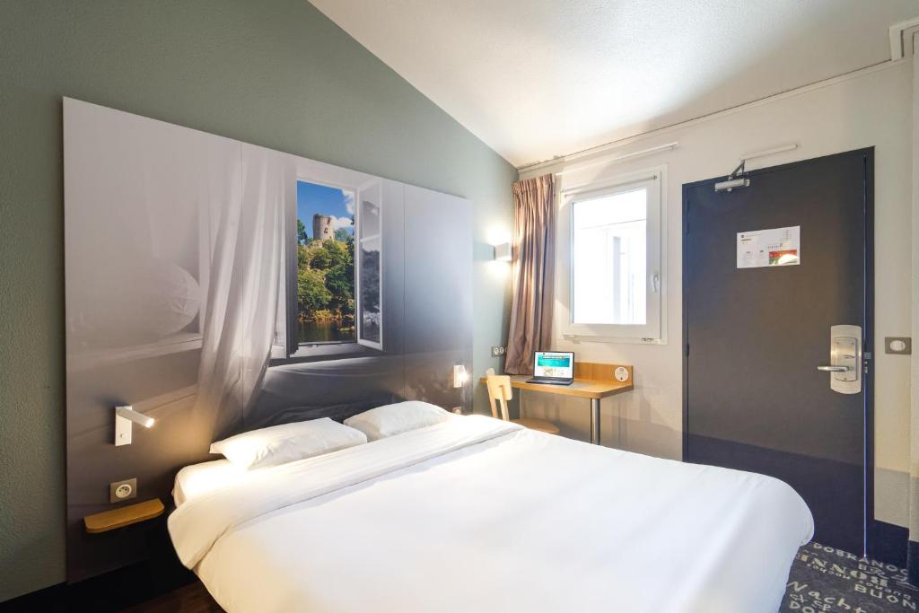 DéolsB&B HOTEL CHATEAUROUX Aéroport的卧室设有一张白色大床和一扇窗户。