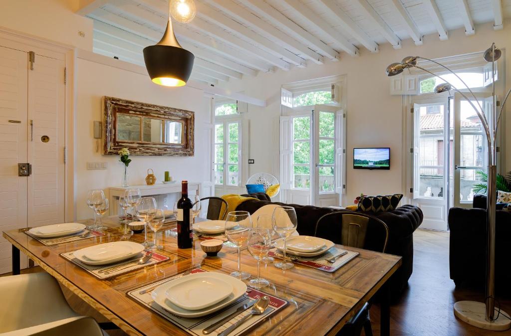 庞特维德拉Verdura Suites ArchSense Apartments的用餐室配有带盘子和酒杯的桌子