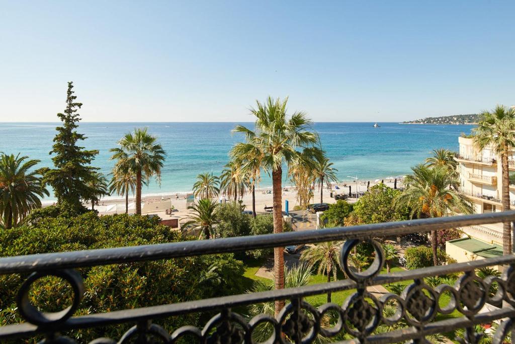 芒通皇家威斯敏斯特蓝色假日酒店的享有棕榈树海滩和大海的景色