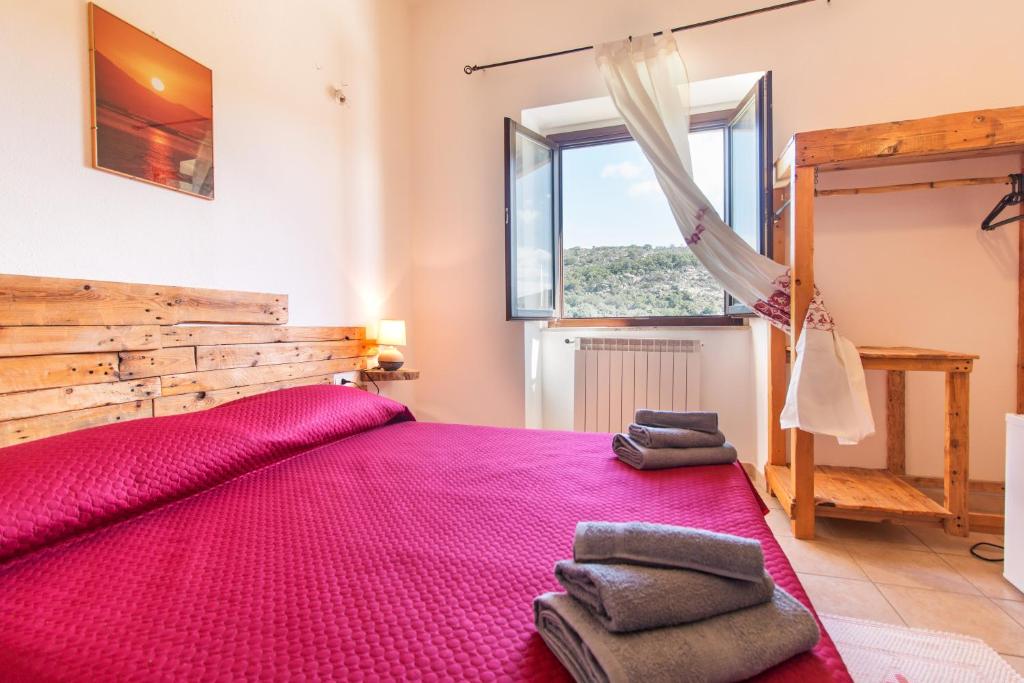 IrgoliRistoro Norghio的卧室设有一张粉红色的大床和一扇窗户。
