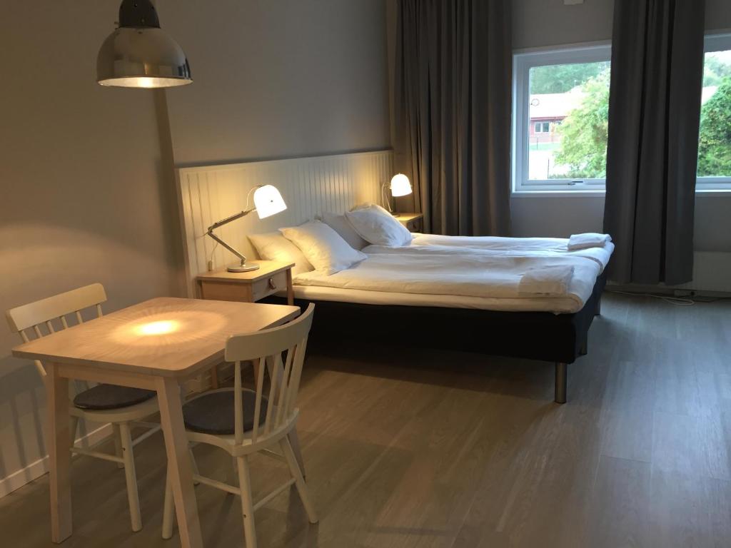 韦克舍Vallabiten Rum och Lägenheter的卧室配有1张床、1张桌子和1张桌子以及椅子。