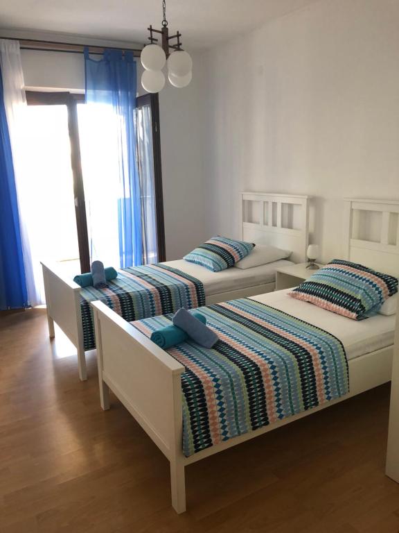 帕格Apartmani Eta的卧室内的两张床,配有蓝色枕头
