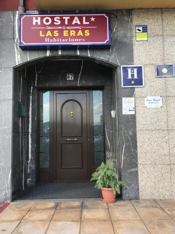 Cubillos del SilHostal Las Eras的一座有门的建筑,前面有植物