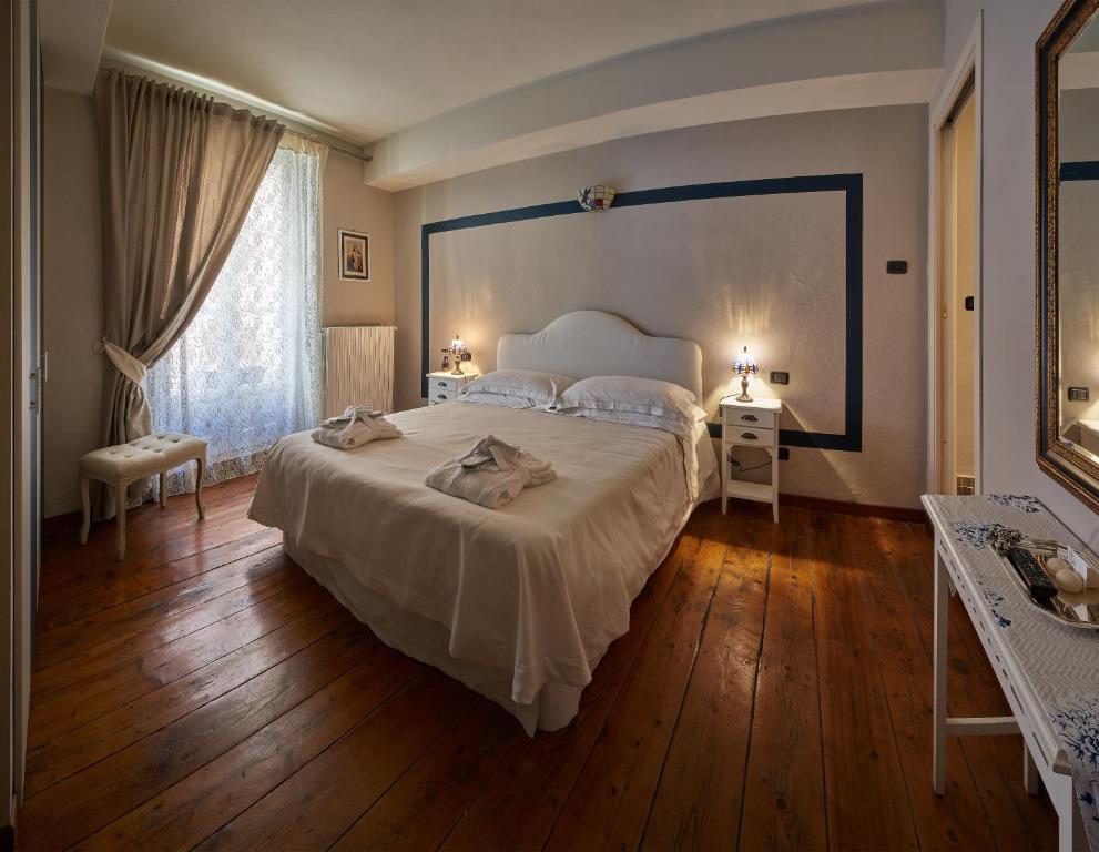 蒙多维Antico Palazzo的卧室配有一张白色的大床,铺有木地板