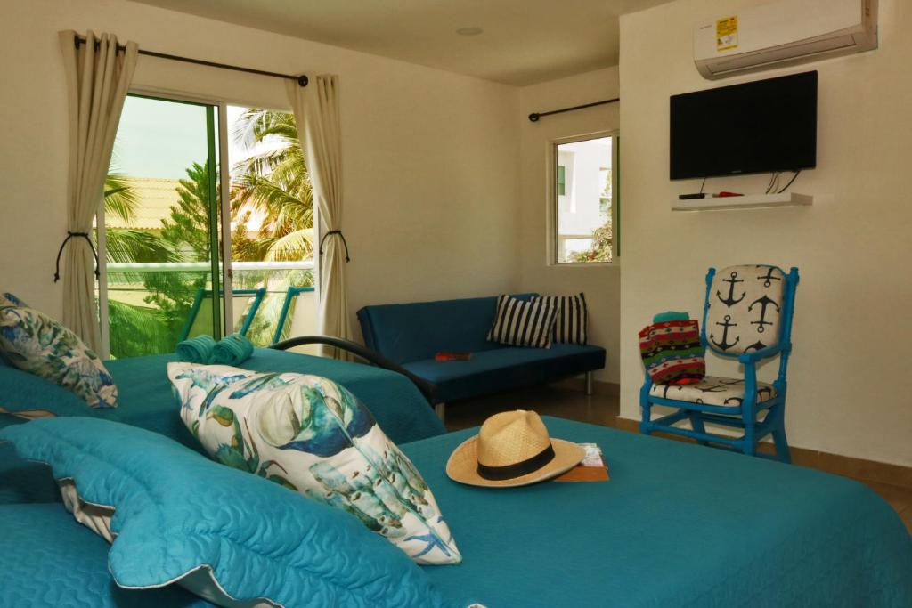圣玛尔塔Casa de Mony的客厅配有蓝色沙发,上面有帽子