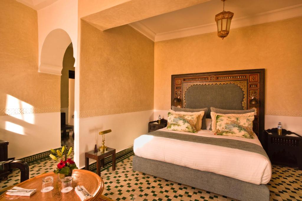非斯Riad Fes - Relais & Châteaux的一间卧室配有一张大床和一张桌子