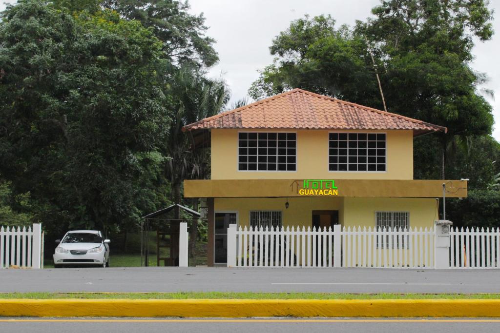 Puerto ArmuellesHostel Guayacan的停在黄色建筑前面的汽车